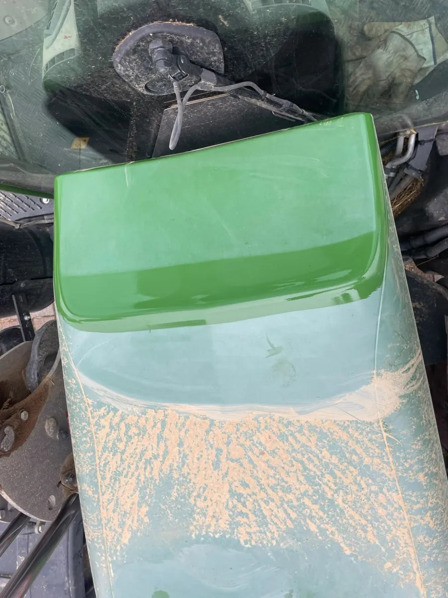 Pièce de tracteur verte rénovée sur une bande
