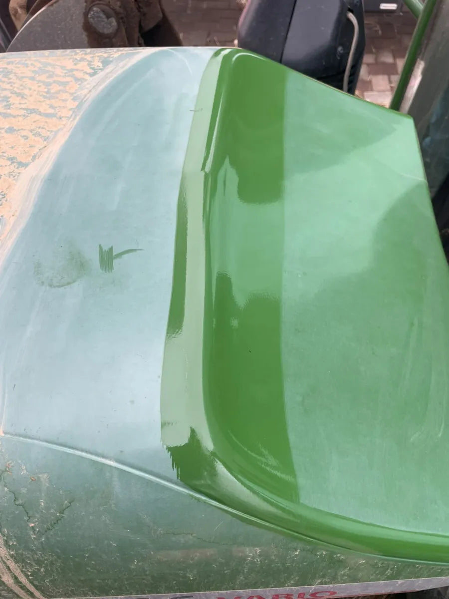 Capot de tracteur vert, moitié terne et moitié rénovée